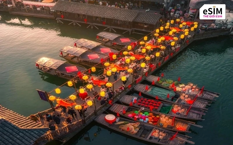 Khói bếp quyện sương mỏng cùng thuyền bán hàng bên bờ sông tạo nên bức tranh sống động bừng tỉnh